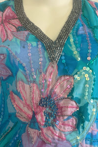 Close-up of a colorful fabric with floral patterns and sequins on a mannequin.